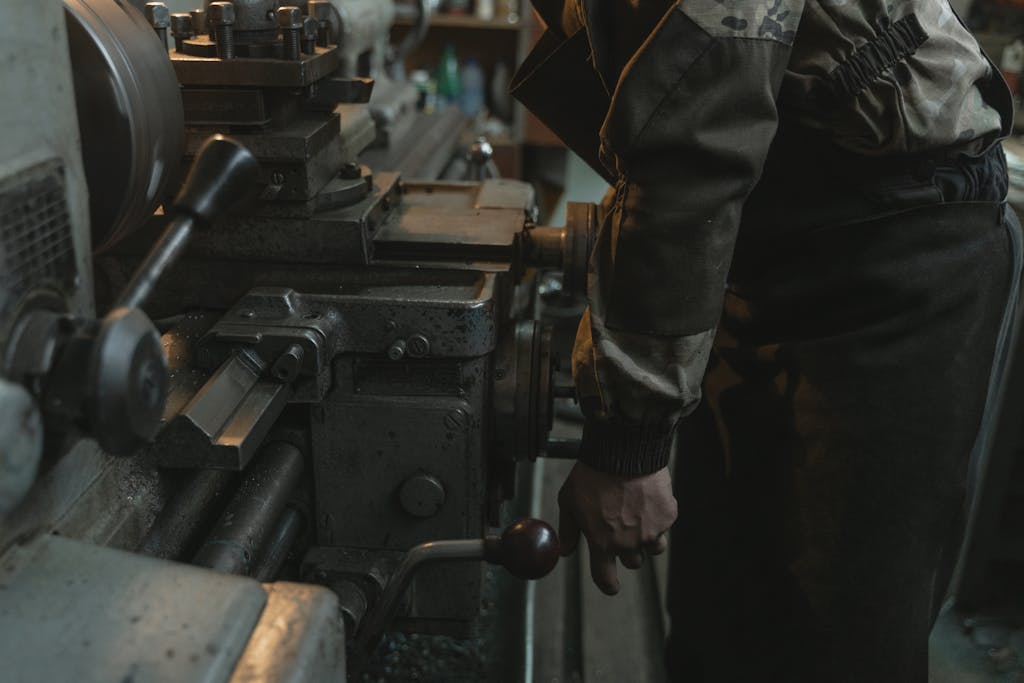 A Man in Gray Jacket Using an Industrial Equipment